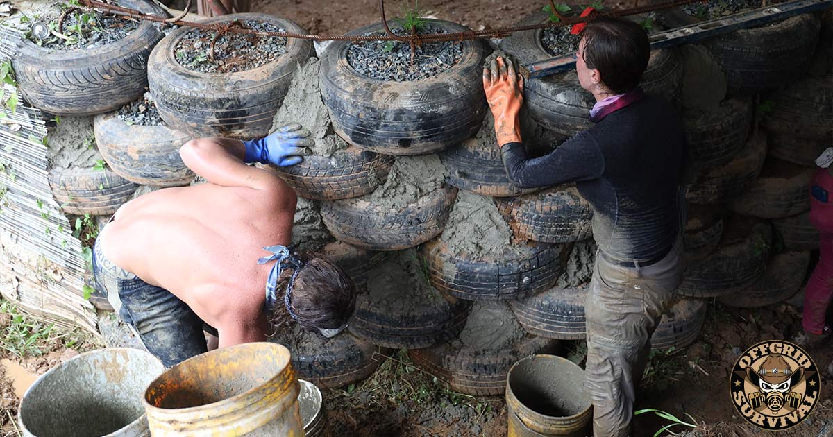 People building an earthship home with tires
